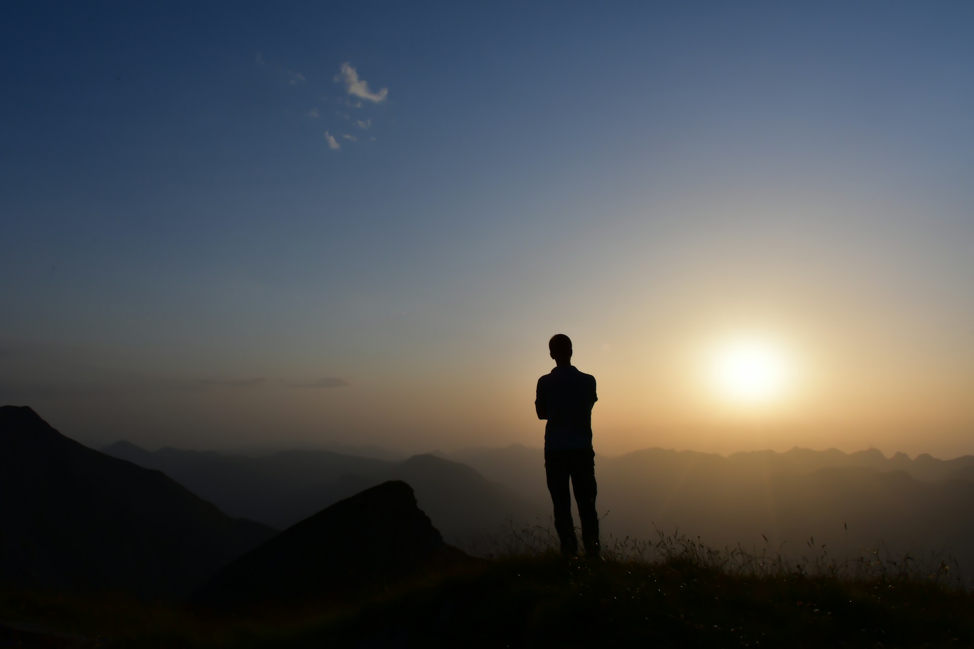 usiness leader standing on a mountain ridge looking out over a vast landscape at sunrise, representing strategic perspective on AI competitive advantage